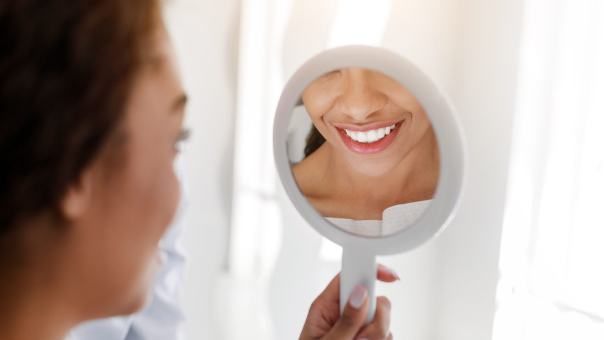 Close up of white smile in mirror, african woman visiting dentist